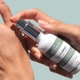 des mains de femme tiennent un flacon vaporisateur d'eau florale régénérante