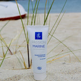 Un tube de masque purifiant pour le visage de la marque Passion Marine posé dans le sable sur une plage bretonne