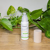 Sur du parquet, un flacon de soin hydratant anti-imperfections au miel de Manuka de la marque Cosmoz