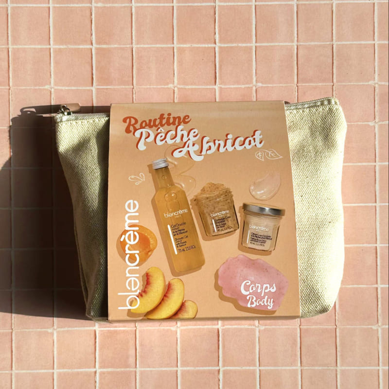 Sur un carrelage rose de salle de bain est posée une trousse de toilette en tissu écru de la marque Blancrème