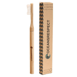 Sur fond transparent, une brosse à dent en bambou rechargeable avec une tête amovible, accompagnée de son étui en carton