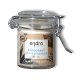 Sur un fond transparent un pot en verre de déodorant solide en baume pour peaux sensibles de la marque ENDRO