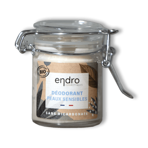 Sur un fond transparent un pot en verre de déodorant solide en baume pour peaux sensibles de la marque ENDRO