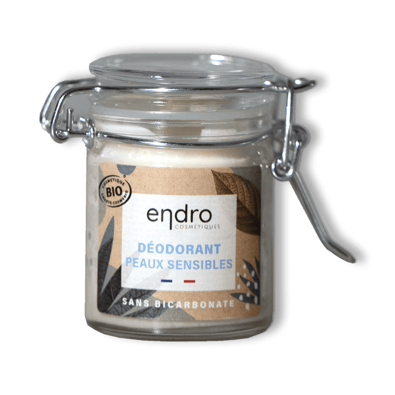 Sur un fond transparent un pot en verre de déodorant solide en baume pour peaux sensibles de la marque ENDRO