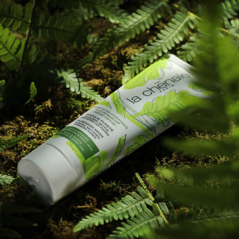 Dans la nature, au milieu de la mousse et des feuillages, un tube de masque purifiant de la marque La Chênaie