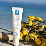 Sur une plage, un tube de baume à lèvres réparateur de la marque Passion Marine