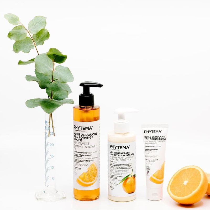Sur fond blanc, une huile de douche 2-en-1, un lait régénérant hydratant pour le corps et un tube d'huile de douche